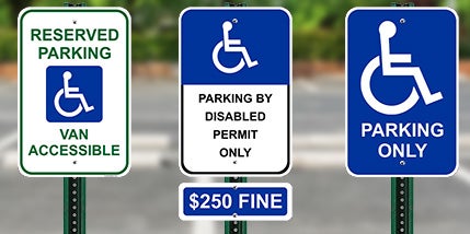 Various Handicap Parking Signs With Wheelchair Symbols Posted In A Parking Lot