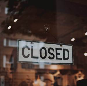 Closed Sign Hanging on a Glass Window Door