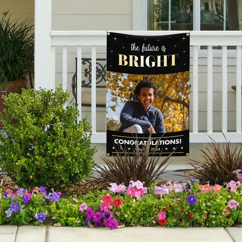 The Future Is Bright Graduation Banner Hanging On A Railing With A Male Student's Photo