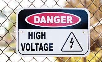 high voltage sign on fence