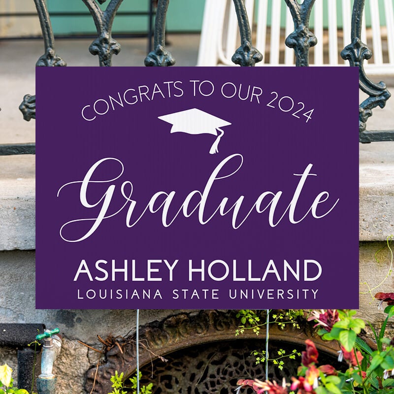 Congrats to our graduate yard sign displayed by a fence