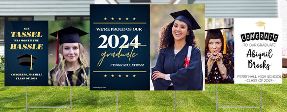 Three different graduation yard signs displayed on a lawn with metal H stakes