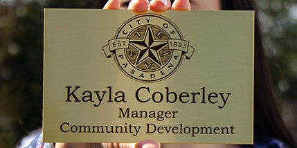 Custom engraved brass sign with a city logo and a name and job title engraved below