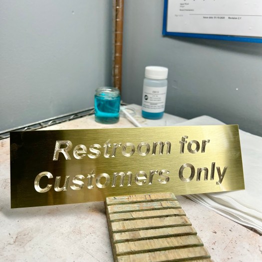 An Engraved Brass Plate Saying Restroom for Customers Only
