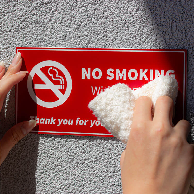 Engraved Plastic Sign Being Wiped Clean with a Washcloth