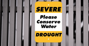Conserve water sign on fence